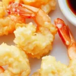 Crispy shrimp tempura served with a soy-based dipping sauce.