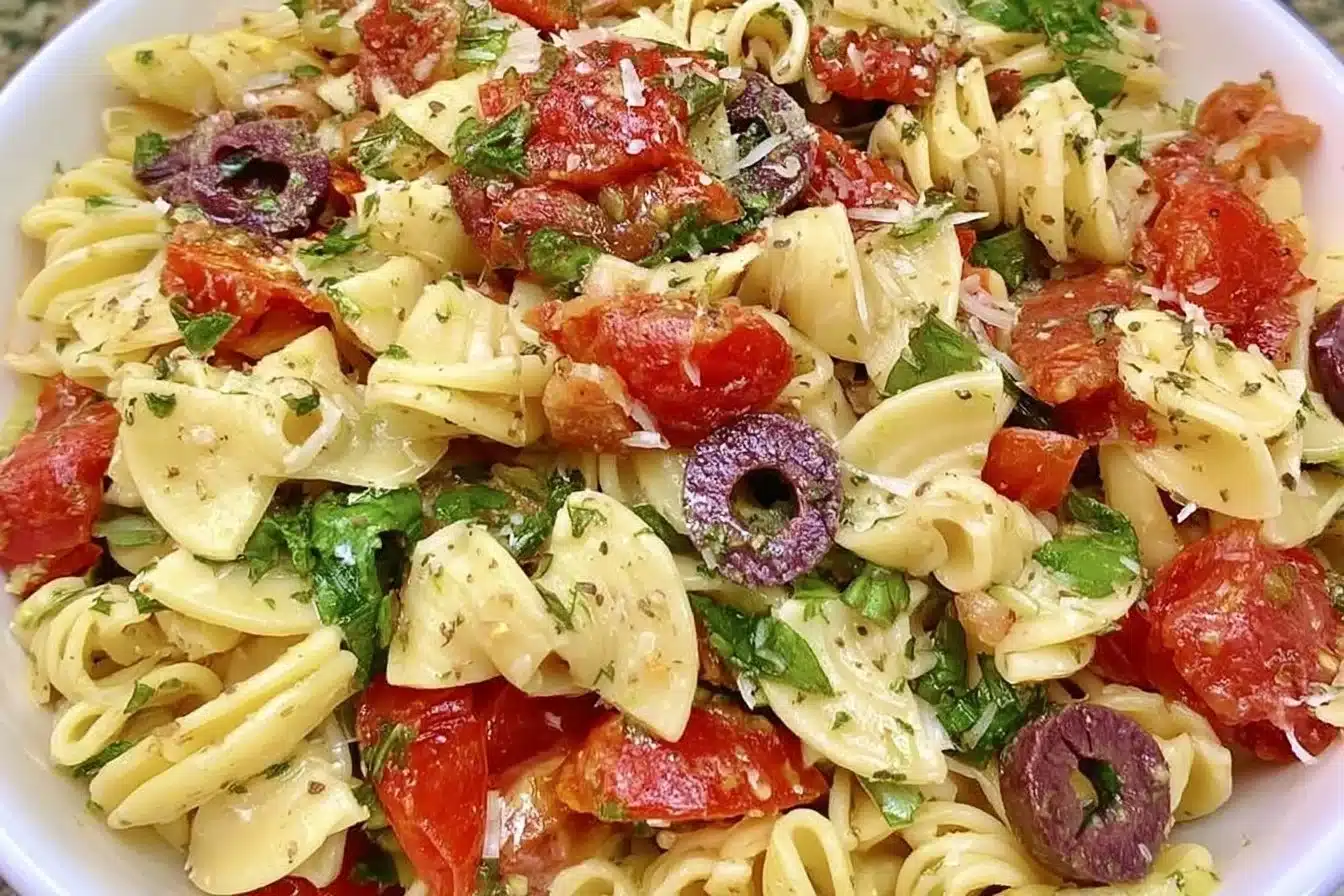 Classic pasta salad in a bowl with colorful vegetables and dressing
